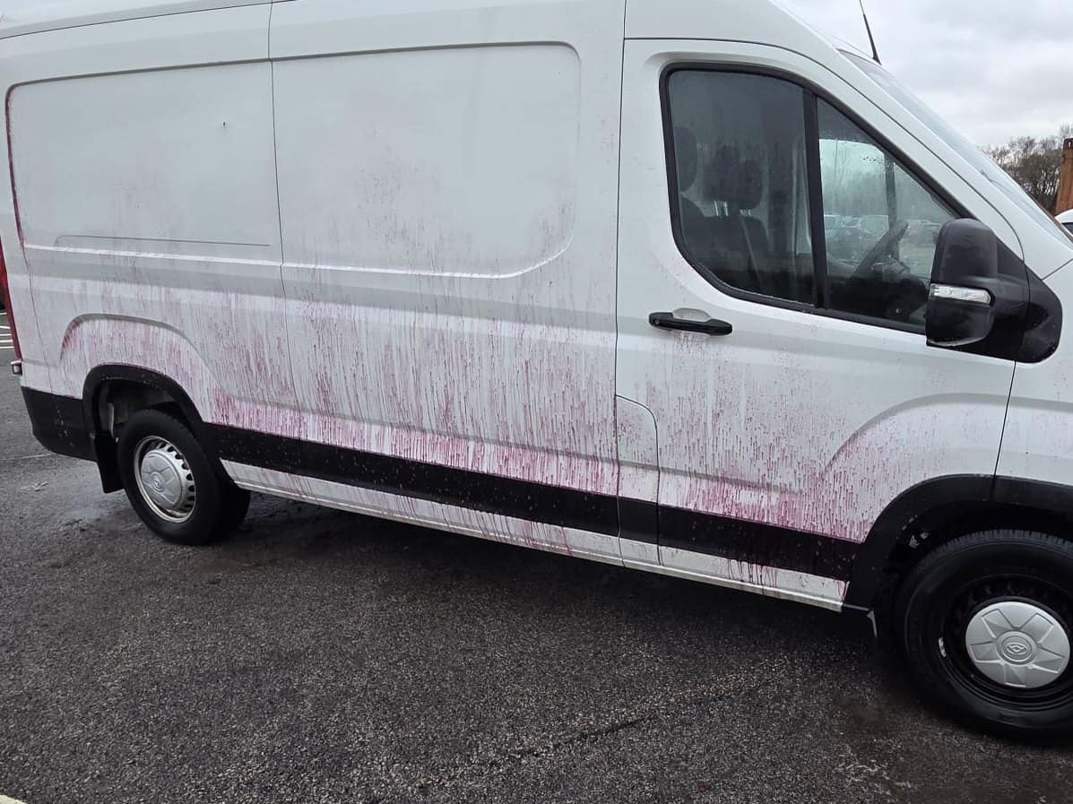 A white panel van before its wash, iron fallout remover running purple down the side
