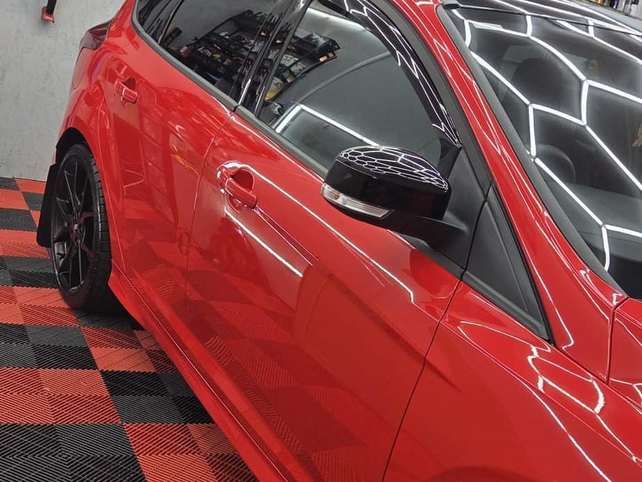 The side of a red Ford Focus RS in the studio after paint protection film was fitted