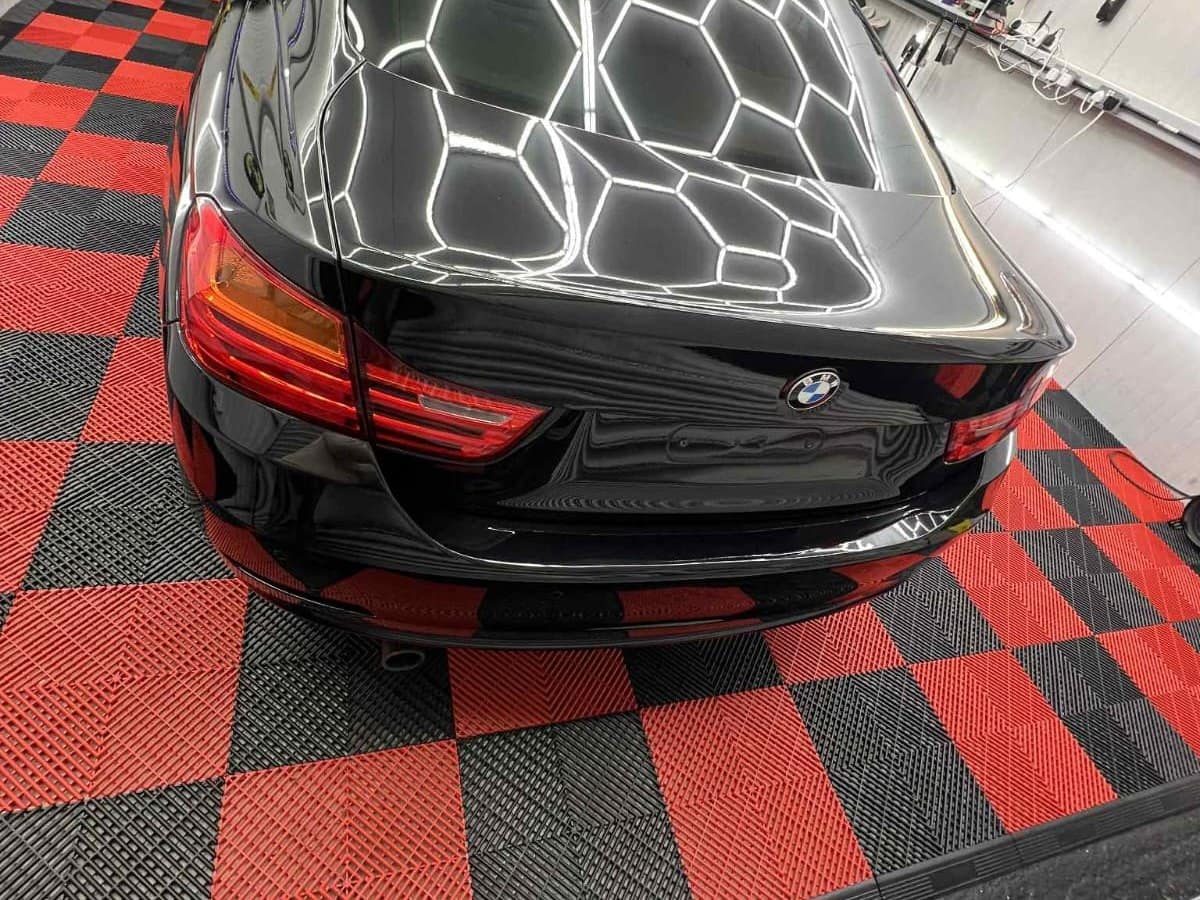 A black BMW finished in the studio, the hexagon lights reflected cleanly across the paint
