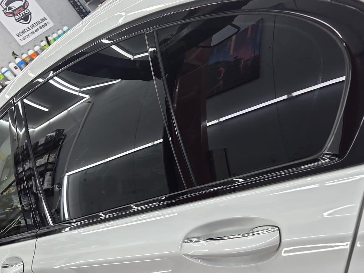 A white car's tinted rear windows in the studio