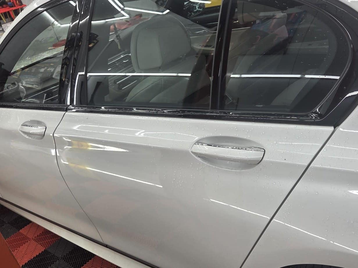 A white car's rear door with freshly tinted windows in the studio