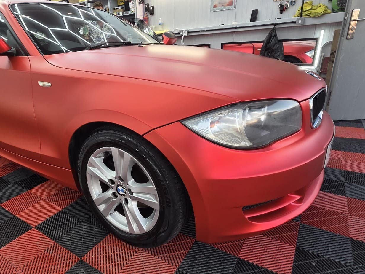 A BMW 1 Series coupé wrapped in satin red in the studio